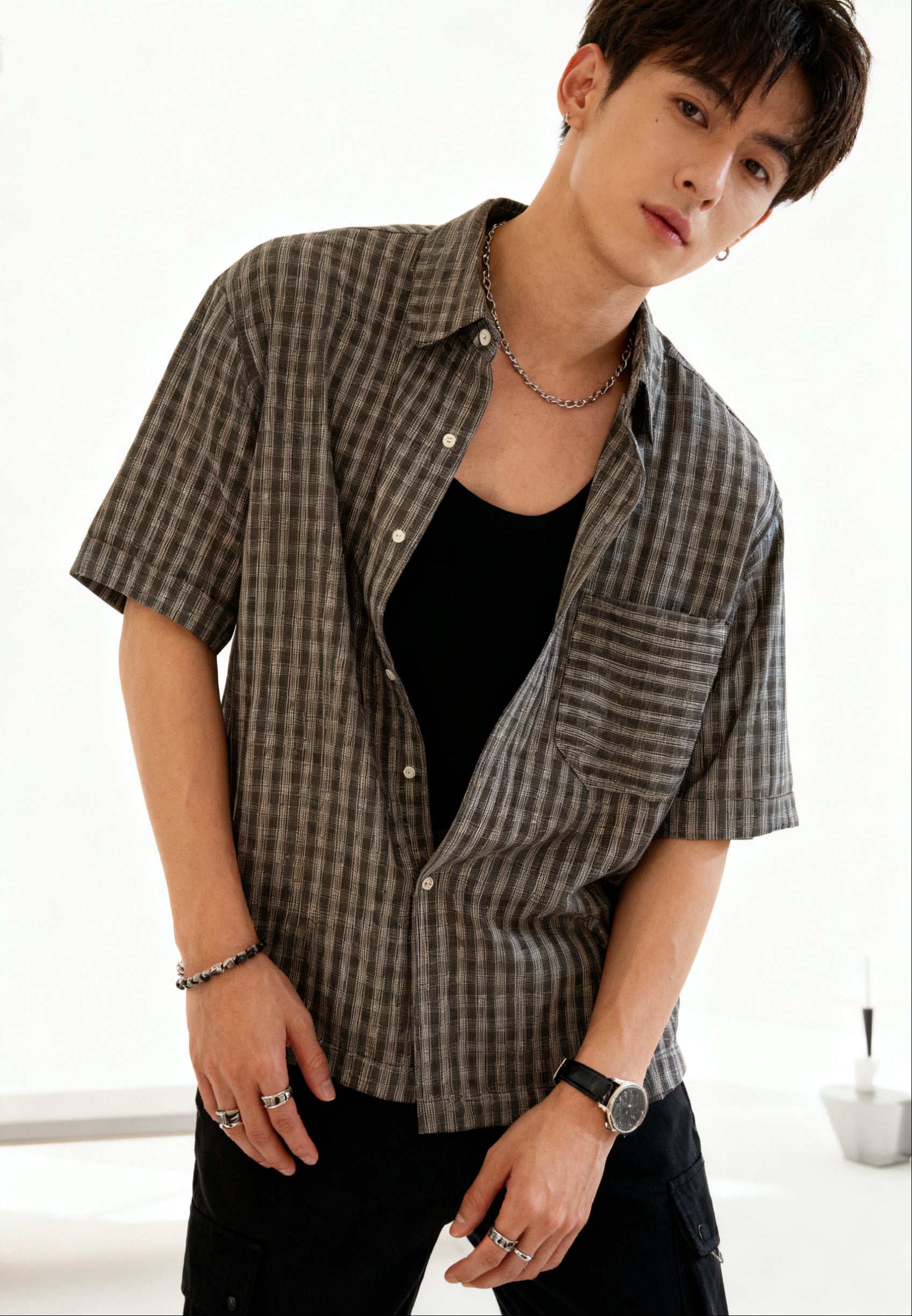 Person wearing a checkered shirt in a minimalistic indoor setting