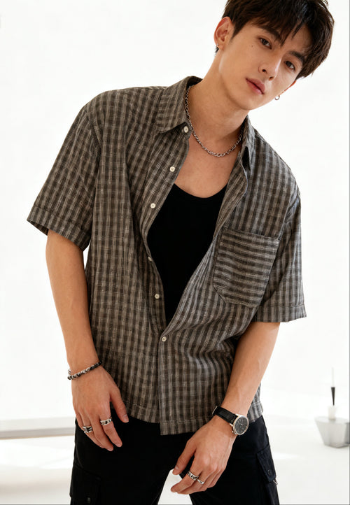 Person wearing a checkered shirt in a minimalistic indoor setting