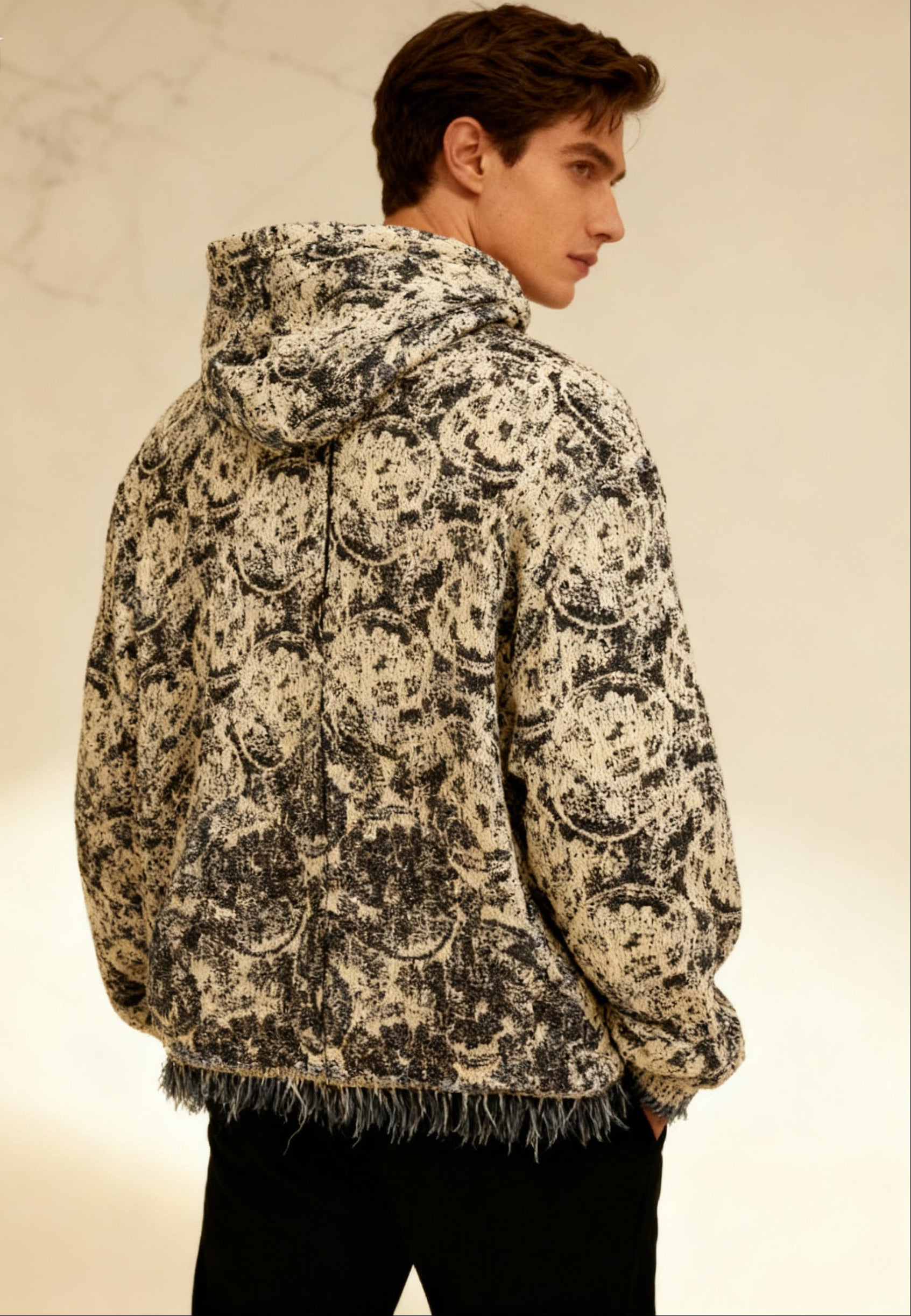 Person wearing a patterned jacket with a neutral background